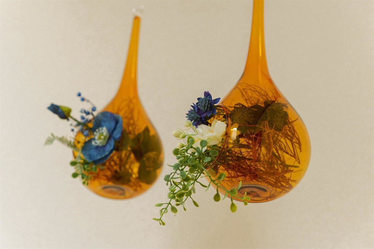 ガラスの花器に生けた、青い花とグリーン。